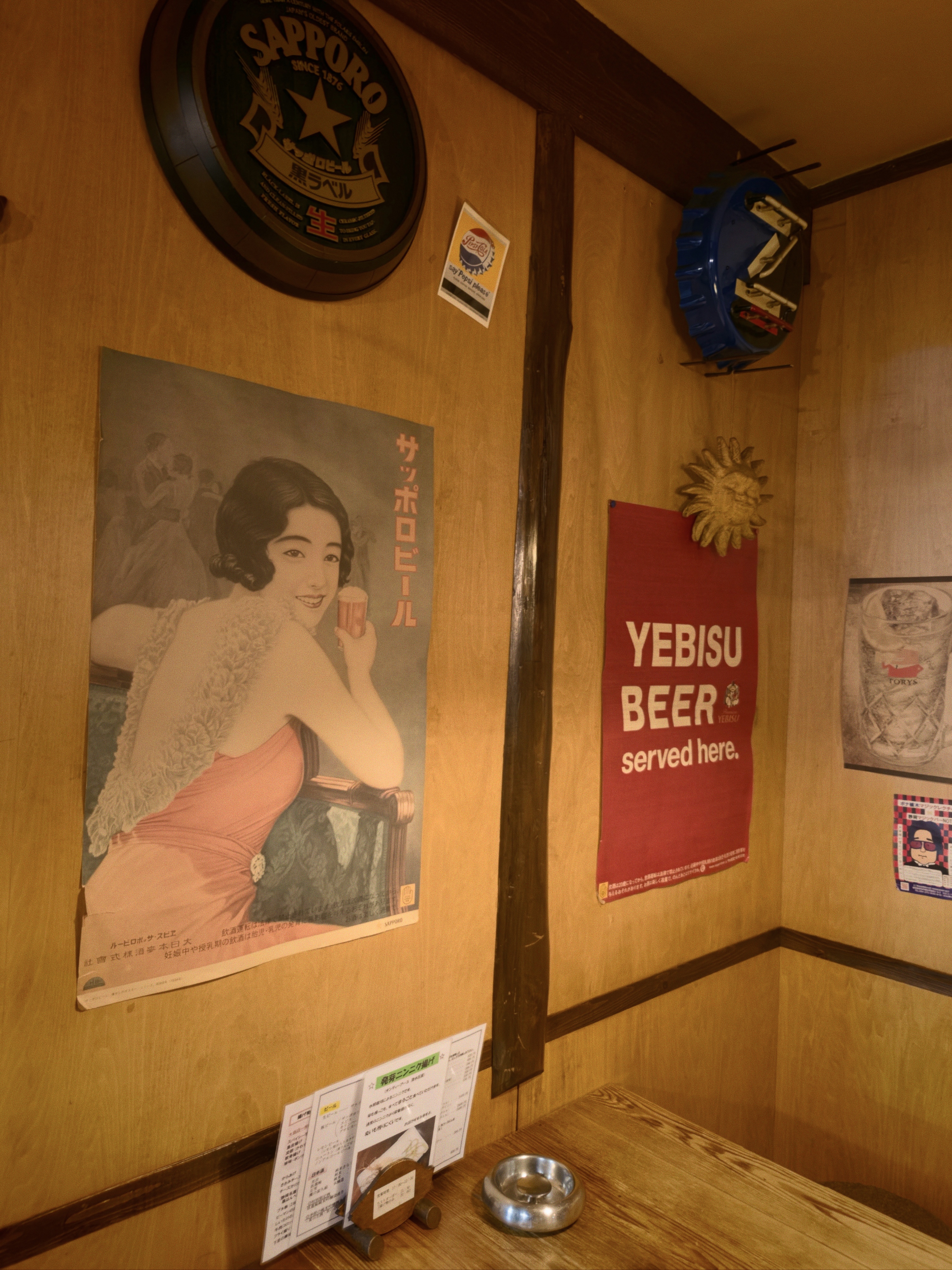 店内に飾られた古いサッポロビールの美人ポスターとYEBISU BEERの赤い旗