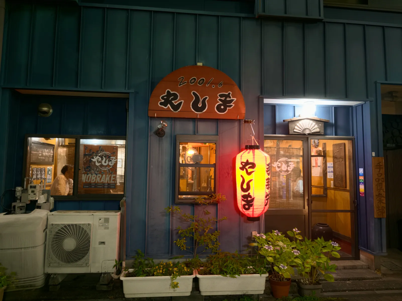 夜の手羽先やしま外観。「2001.6 やしま」の看板と赤提灯が灯る